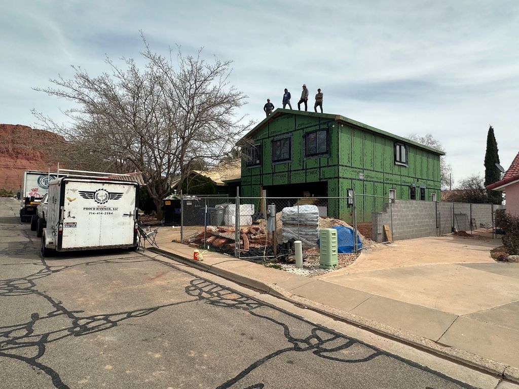 Proud Hammer Homes framing crew standing on the roof edge of a two-story ZIP System sheathed project