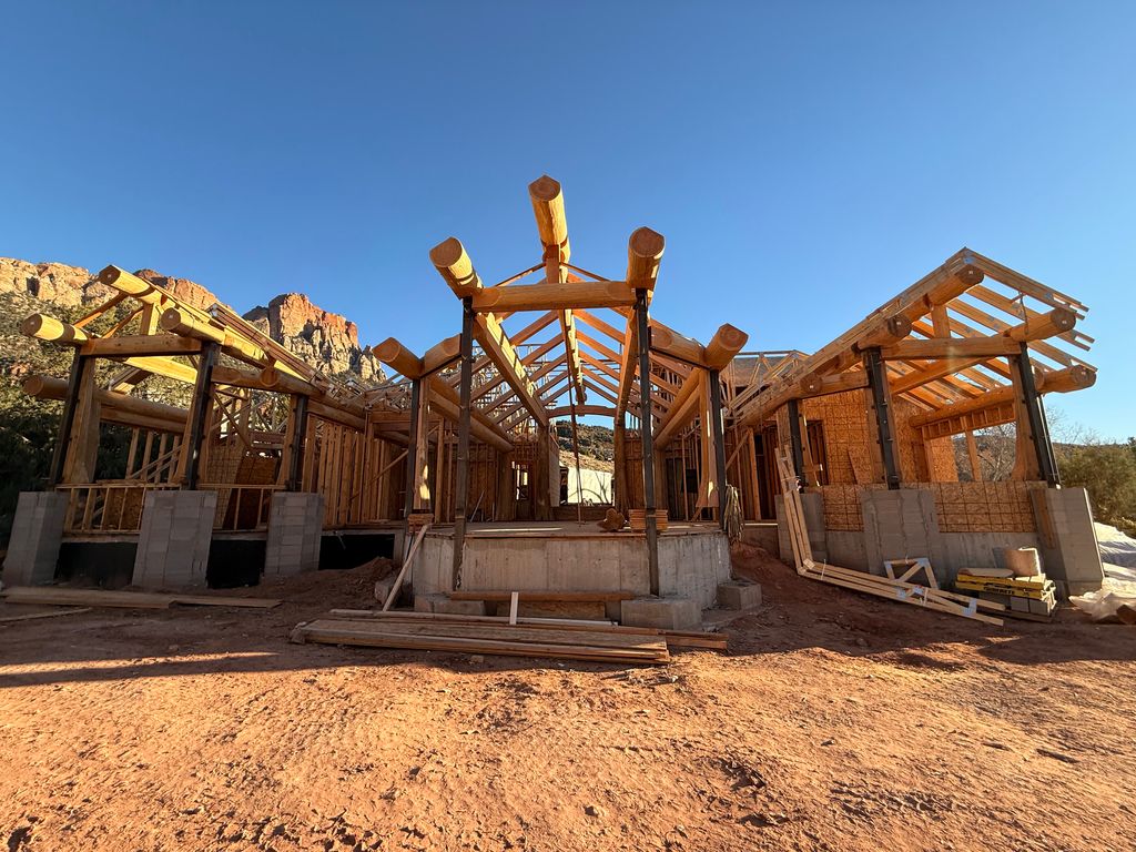Large log-style home structure framed by Proud Hammer Homes